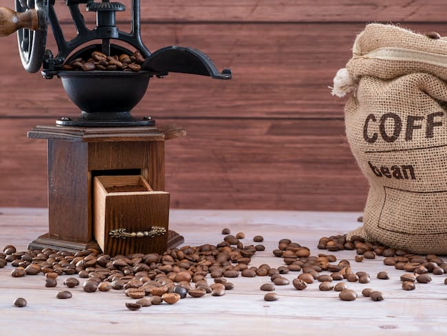 Molinillo de café manual vintage con granos de café - Foto vía Getty images