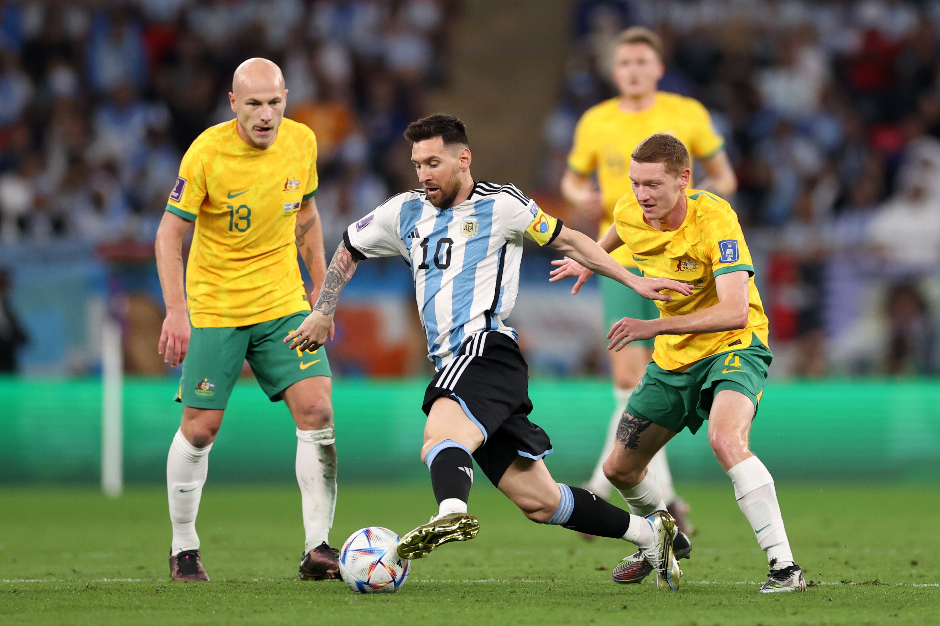 DOHA, QATAR - DECEMBER 03: Lionel Messi of Argentina controls the ball against Kye Rowles and Aaron Mooy of Australia during the FIFA World Cup Qatar 2022 Round of 16 match between Argentina and Australia at Ahmad Bin Ali Stadium on December 03, 2022 in Doha, Qatar. (Photo by Michael Steele/Getty Images)