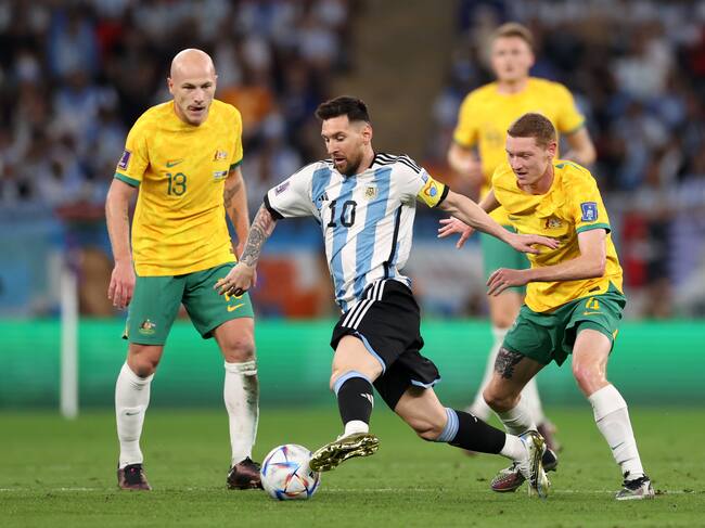 DOHA, QATAR - DECEMBER 03: Lionel Messi of Argentina controls the ball against Kye Rowles and Aaron Mooy of Australia during the FIFA World Cup Qatar 2022 Round of 16 match between Argentina and Australia at Ahmad Bin Ali Stadium on December 03, 2022 in Doha, Qatar. (Photo by Michael Steele/Getty Images)