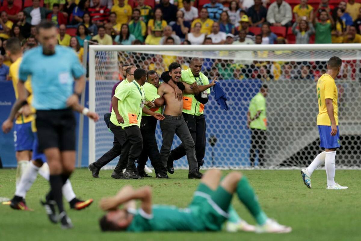 Un fan es detenido por los miembros de seguridad del Estadio Nacional de Brasilia durante el partido Brasil vs Iraq que terminó empatado 0-0.