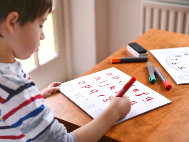 Niño haciendo un ejercicio de escritura (Foto vía Getty Images)