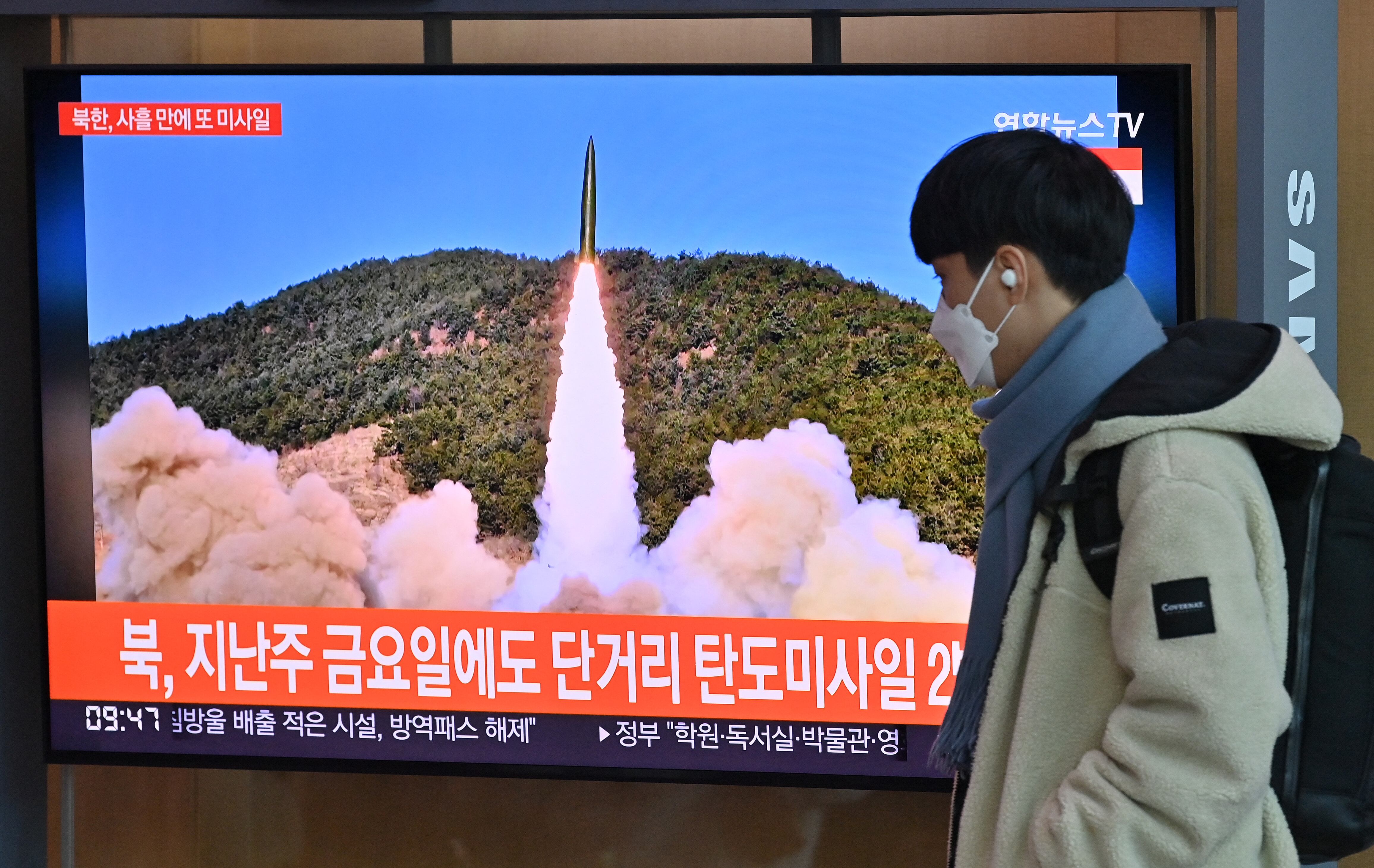 A man walks past a television screen showing a news broadcast with file footage of a North Korean missile test, at a railway station in Seoul on January 17, 2022, after North Korea fired an unidentified projectile eastward in the country's fourth suspected weapons test this month according to the South's military. (Photo by Jung Yeon-je / AFP) (Photo by JUNG YEON-JE/AFP via Getty Images)