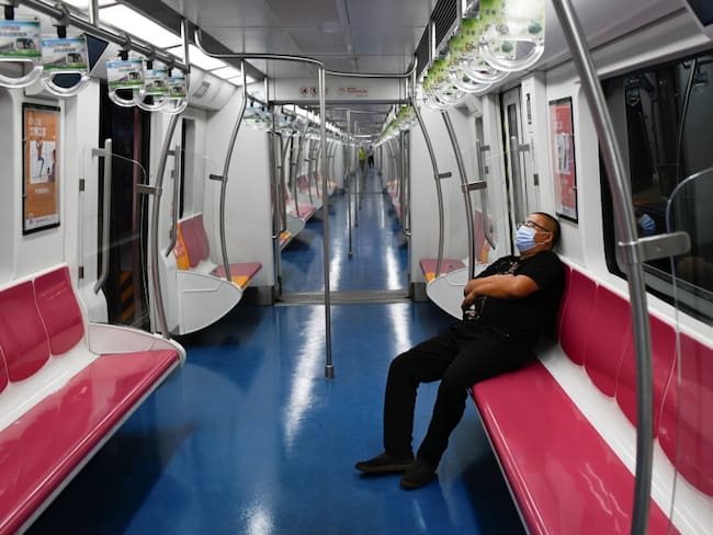 Un hombre usando un tapabocas mientas va en el metro, en Beijing. En China, miles de personas están siendo testeadas por COVID-19.