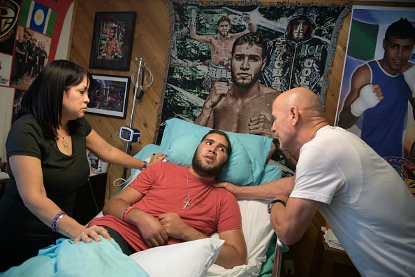 WINTER PARK, FL-MAY 22: Nieves Melendez, left, and Richard Colon tend to their son, former professional boxer Prichard Colon, while he lies in a vegetative state in his bedroom at his family home in Winter Park, Fla., Monday, May 22, 2017. Prichard Colon suffered a traumatic brain injury during his bout against Terrel Williams. (Photo by Phelan M. Ebenhack/For The Washington Post via Getty Images)