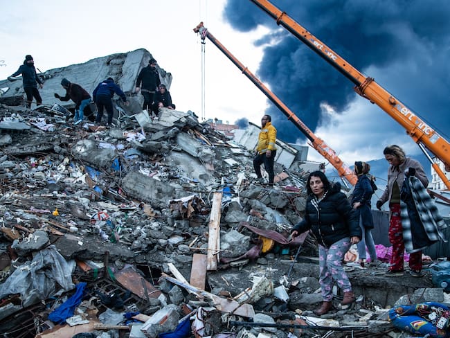 Sobrevivientes del terremoto esperan noticias de sus seres queridos, que se cree que están atrapados bajo el edificio derrumbado el 7 de febrero de 2023 en Iskenderun, Turquía. Foto de Burak Kara/Getty Images.