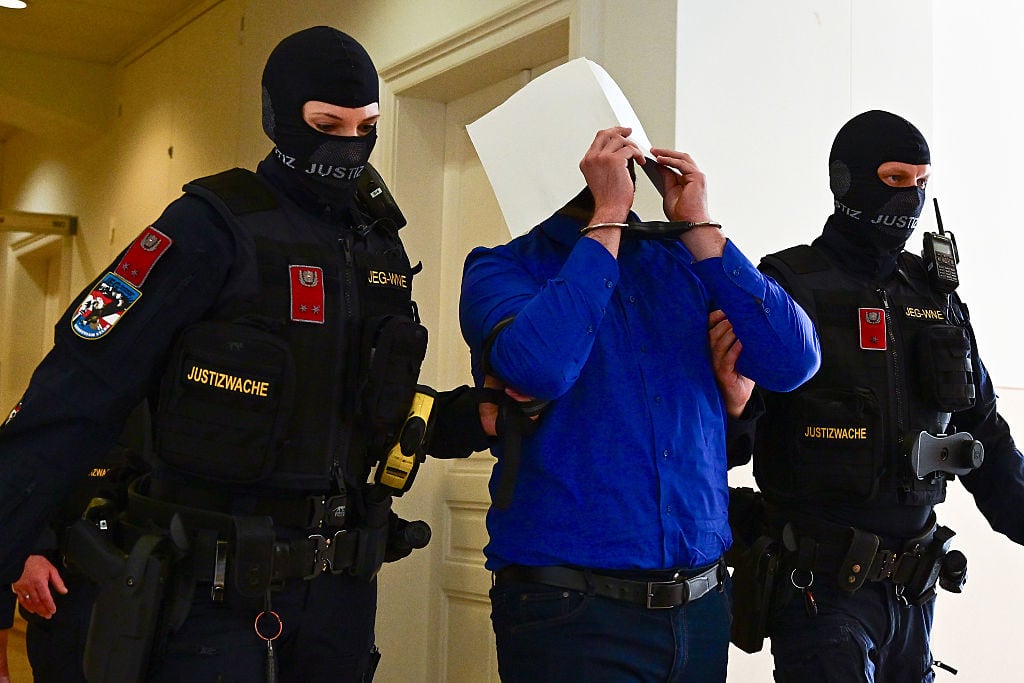 WIENER NEUSTADT, AUSTRIA - APRIL 28: Defendant Beran A. is lead out of the hearing room during a break on the first day of the Taylor Swift concert plot trial at Regional Court Wiener Neustadt on April 28, 2026 in Wiener Neustadt, Austria. Two young men are charged with terrorism and other offences over plotting three terrorist attacks. One of them planned to attack a Taylor Swift concert in Vienna in August 2024. Three dates of Taylor Swift's "Eras" tour were canceled in the summer of 2024 after authorities were warned of a plot. (Photo by Christian Bruna/Getty Images)