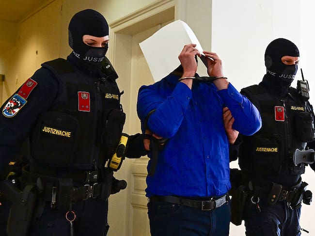 WIENER NEUSTADT, AUSTRIA - APRIL 28: Defendant Beran A. is lead out of the hearing room during a break on the first day of the Taylor Swift concert plot trial at Regional Court Wiener Neustadt on April 28, 2026 in Wiener Neustadt, Austria. Two young men are charged with terrorism and other offences over plotting three terrorist attacks. One of them planned to attack a Taylor Swift concert in Vienna in August 2024. Three dates of Taylor Swift's "Eras" tour were canceled in the summer of 2024 after authorities were warned of a plot. (Photo by Christian Bruna/Getty Images)