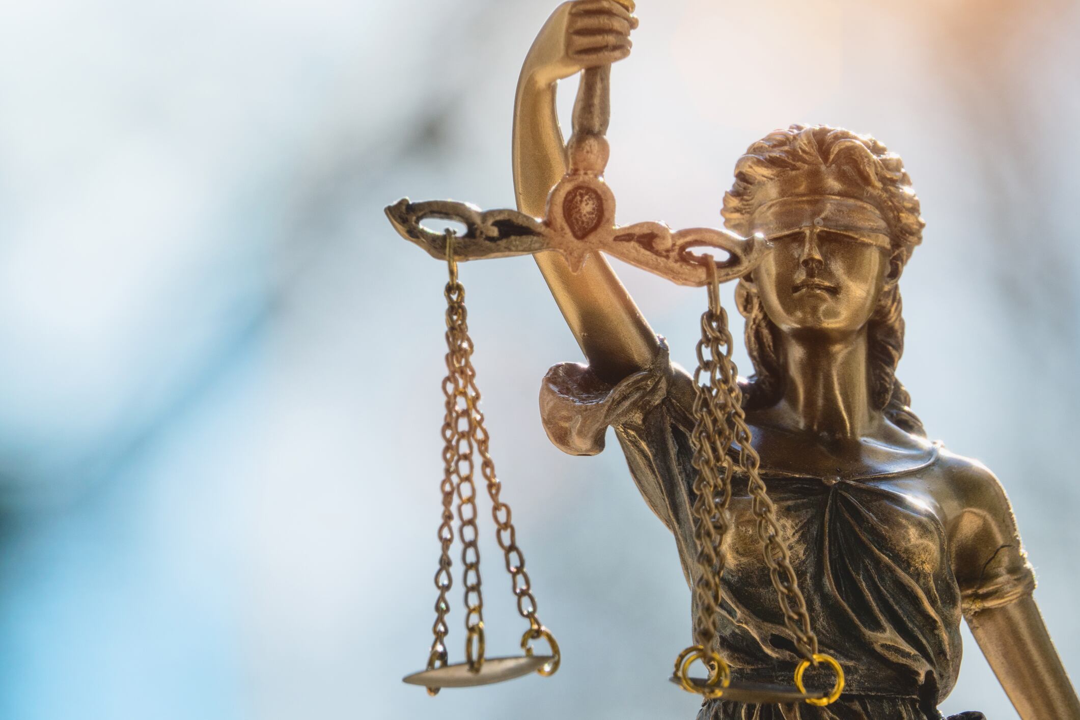 Lady Justice or Justicia in front of blurred background. Goddess of justice.