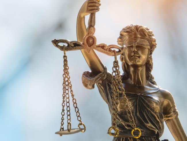 Lady Justice or Justicia in front of blurred background. Goddess of justice.