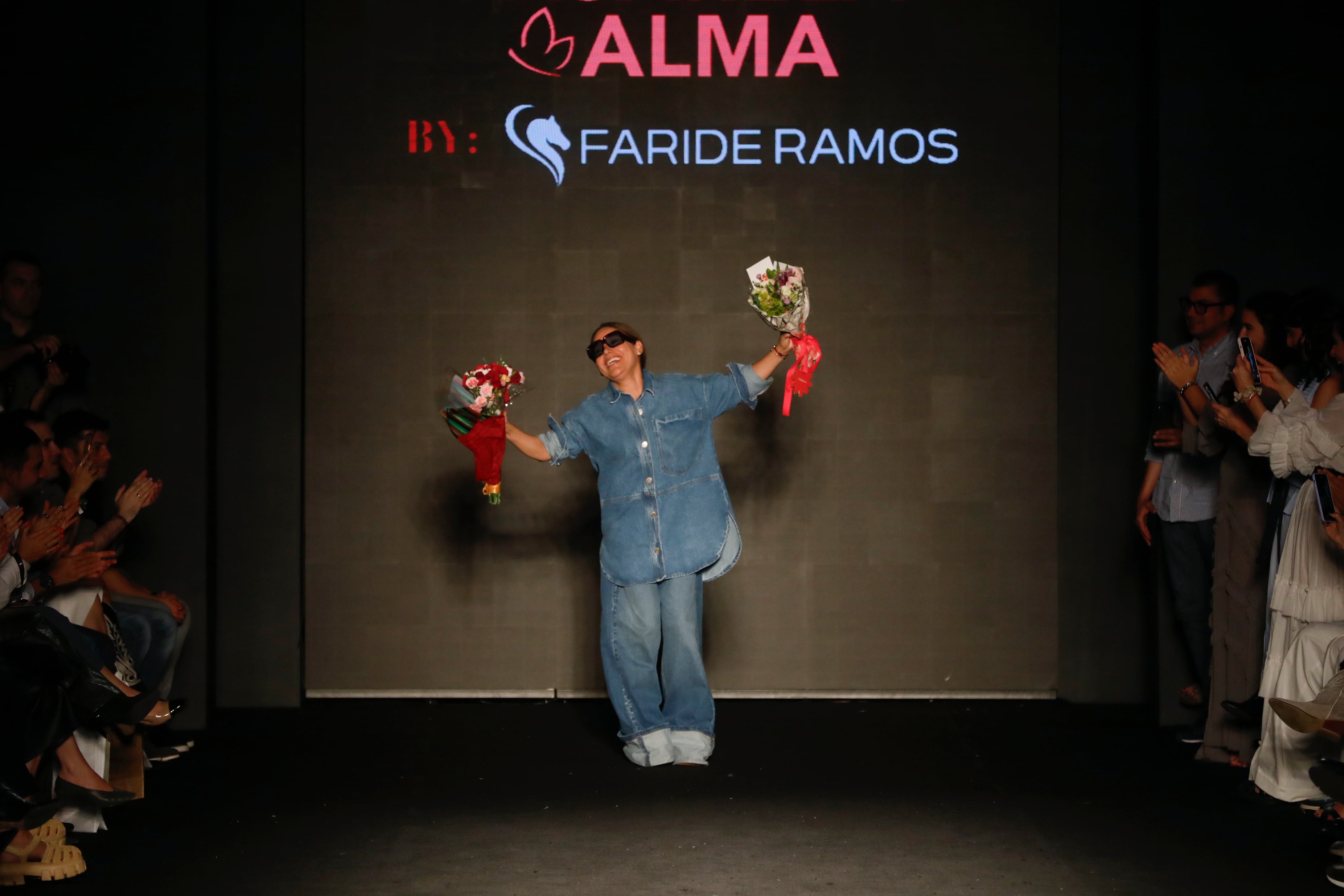 AME4848. MEDELLÍN (COLOMBIA), 25/07/2024.- La diseñadora colombiana Faride Ramos saluda al final la pasarela 'Rosa que linda eres', en colaboración con la fundación Alma Rosa, este jueves, durante la edición 35 de la feria Colombiamoda en Medellín (Colombia). EFE/ Luis Eduardo Noriega Arboleda