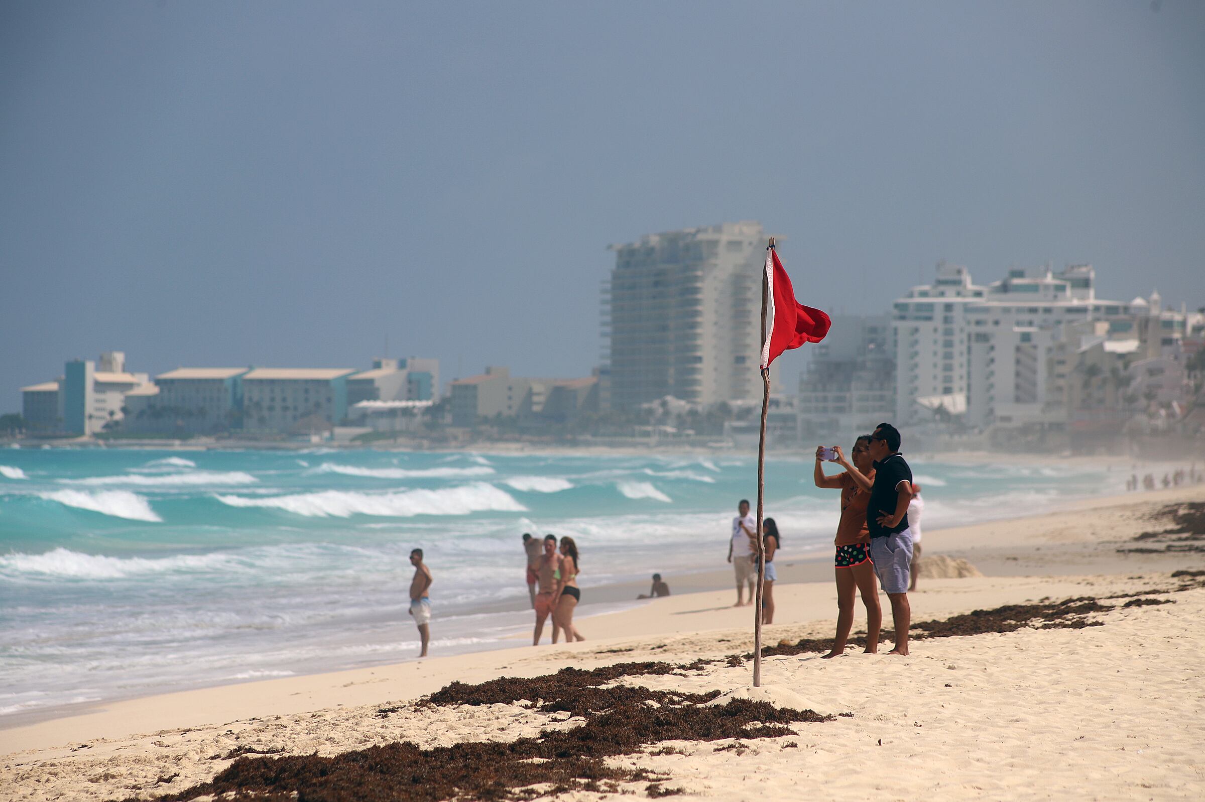 Turistas permanecen en las playas ante el alto oleaje, en el balneario de Cancún, en Quintana Roo (México), previo a la llegada del huracán Beryl.
 EFE/ Lourdes Cruz