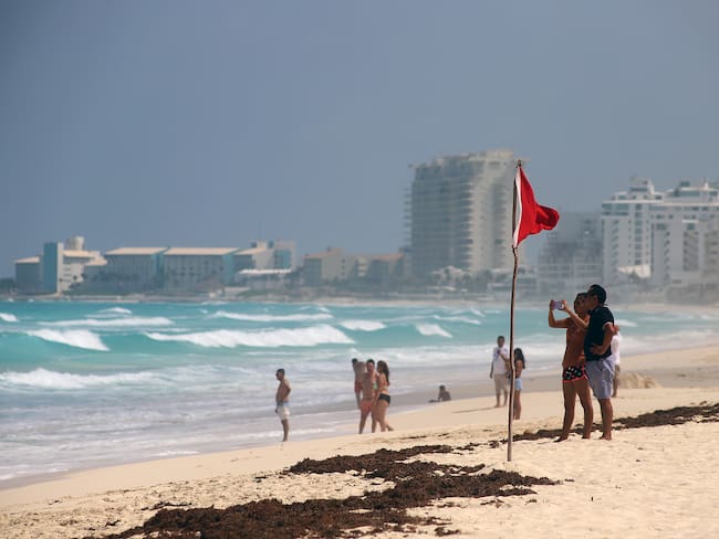 MEX2812. FELIPE CARRILLO PUERTO (MÉXICO), 04/07/2024.- Turistas permanecen en las playas ante el alto oleaje este jueves, en el balneario de Cancún, en Quintana Roo (México). Cinco municipios de la costa del estado de Quintana Roo, Caribe mexicano, fueron declarados en alerta roja, es decir, &quot;peligro máximo&quot; debido a la aproximación del ciclón Beryl, clasificado como huracán de categoría 2 en la escala Saffir-Simpson, informó este jueves la gobernadora del estado, Mara Lezama. EFE/ Lourdes Cruz