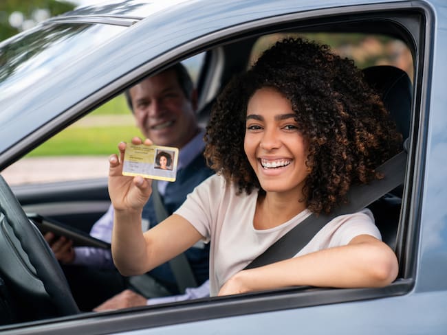 Mujer feliz después de conseguir su licencia de conducción (Getty Images)