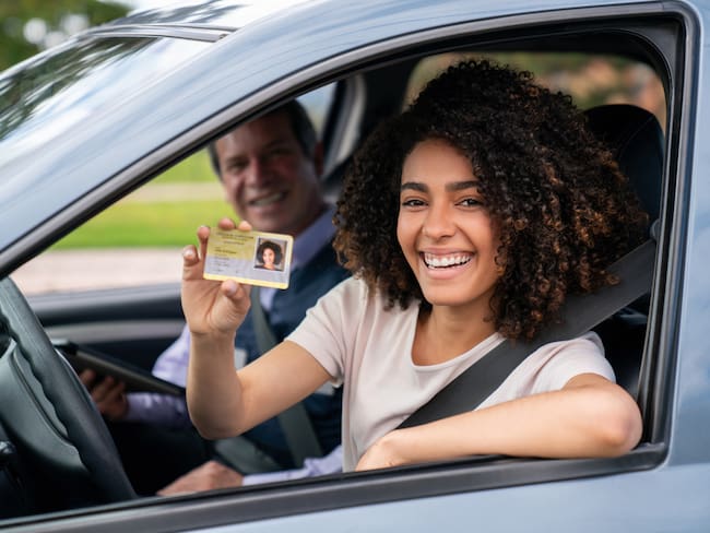 Mujer feliz después de conseguir su licencia de conducción (Getty Images)