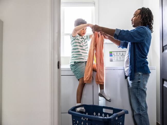 Padre e hijo separando pantalones para lavar - Foto vía Getty Images