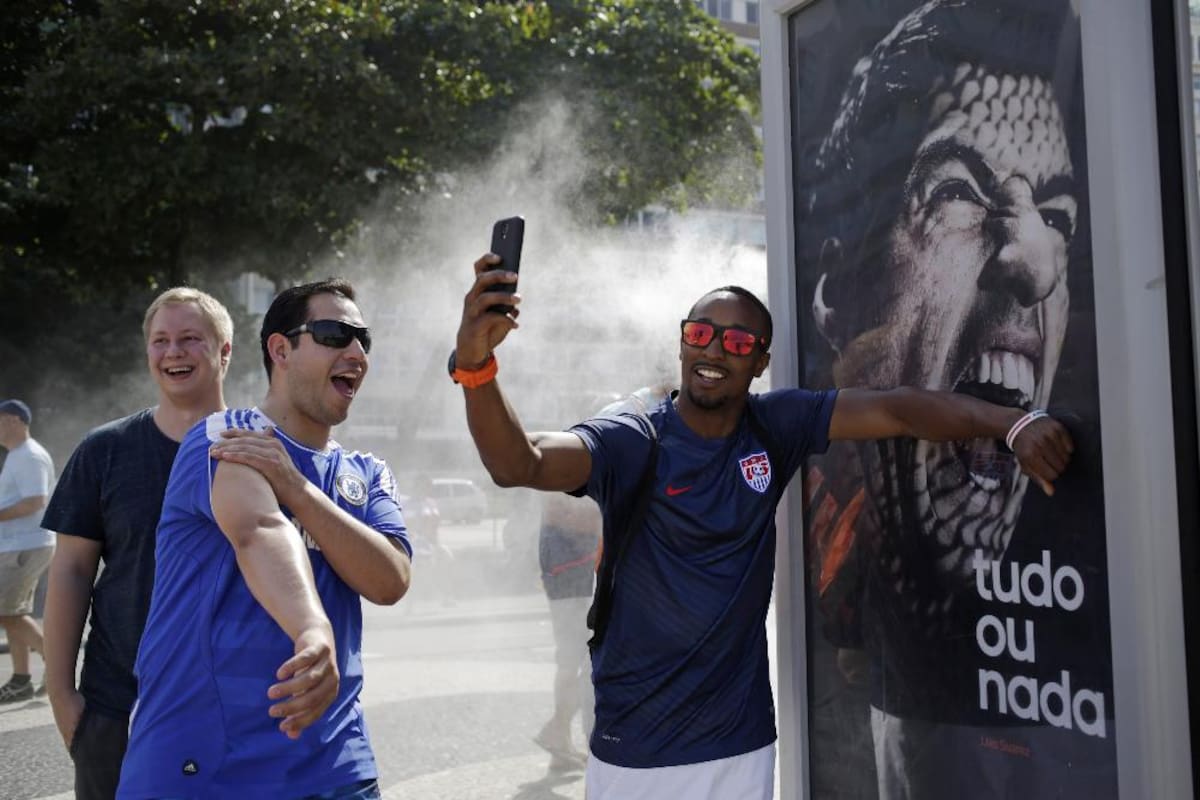 26 de junio 2014. Un aficionado al fútbol de Estados Unidos pretende que el delantero de fútbol de Uruguay Luis Suárez lo está mordiendo, cerca de la playa de Copacabana en Río de Janeiro, Brasil.