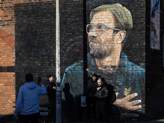 Liverpool (Reino Unido), 26/01/2024.- La gente posa para fotografías junto a un mural del entrenador de Liverpool, Jurgen Klopp, en Liverpool, este viernes. El técnico alemán anunció este viernes su decisión de abandonar el Liverpool a final de temporada, tras nueve años en los que ha ganado todos los títulos importantes, incluyendo la Liga de Campeones y la Premier League, la primera en tres décadas para los 'Reds'.- EFE/ADAM VAUGHAN