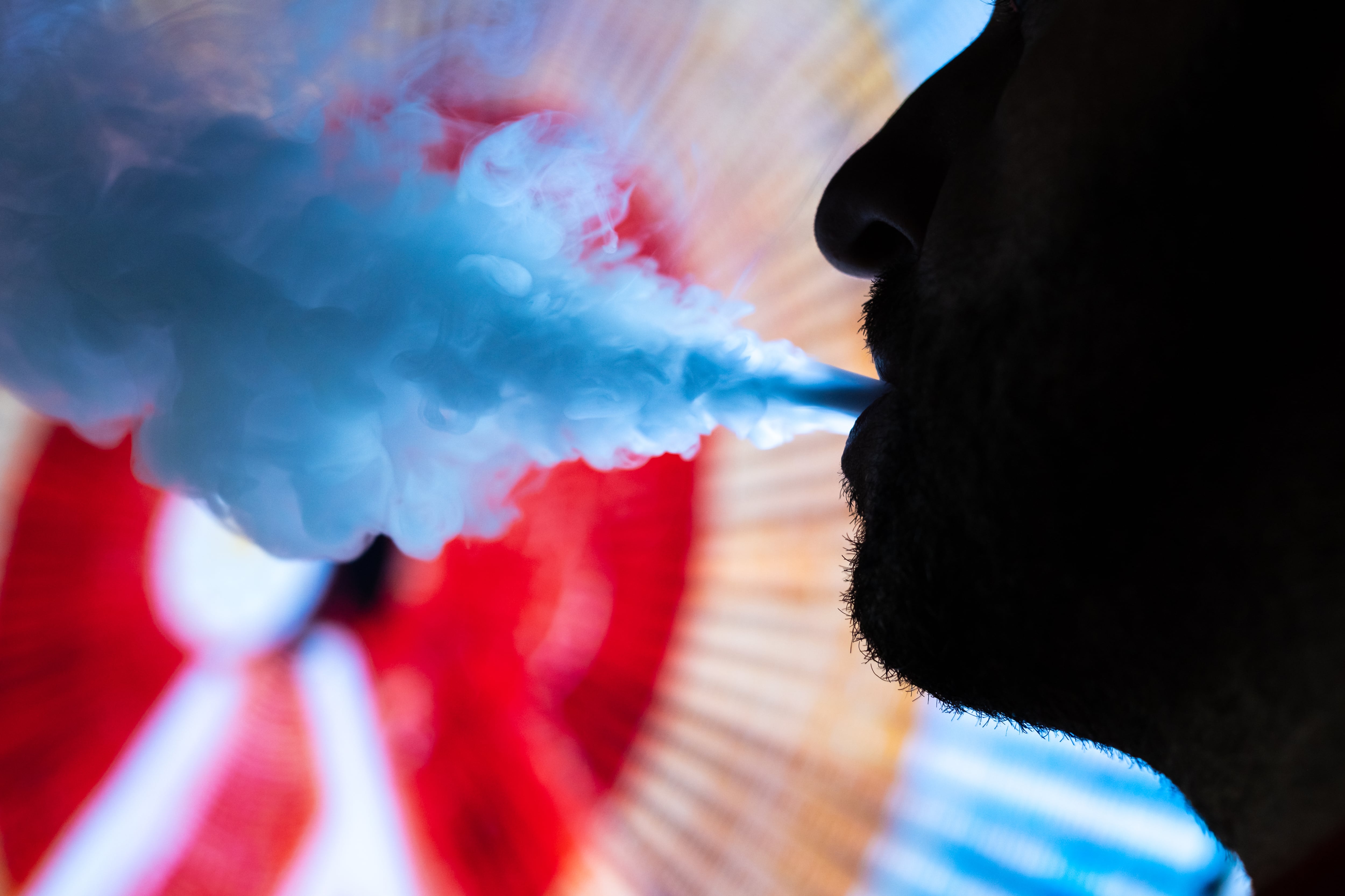 Man smokes an electronic cigarette in town .