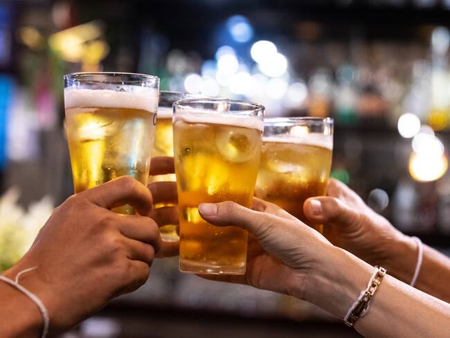 Grupo de amigos tomando cerveza (Foto vía Getty Images)