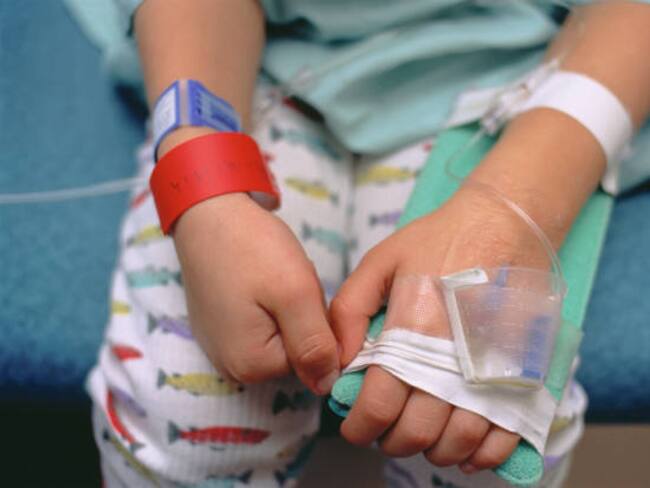 A worried young boy in a hospital bed being treated for croup.The red bracelet is to notify healthcare professionals of an allergy to penicillin.