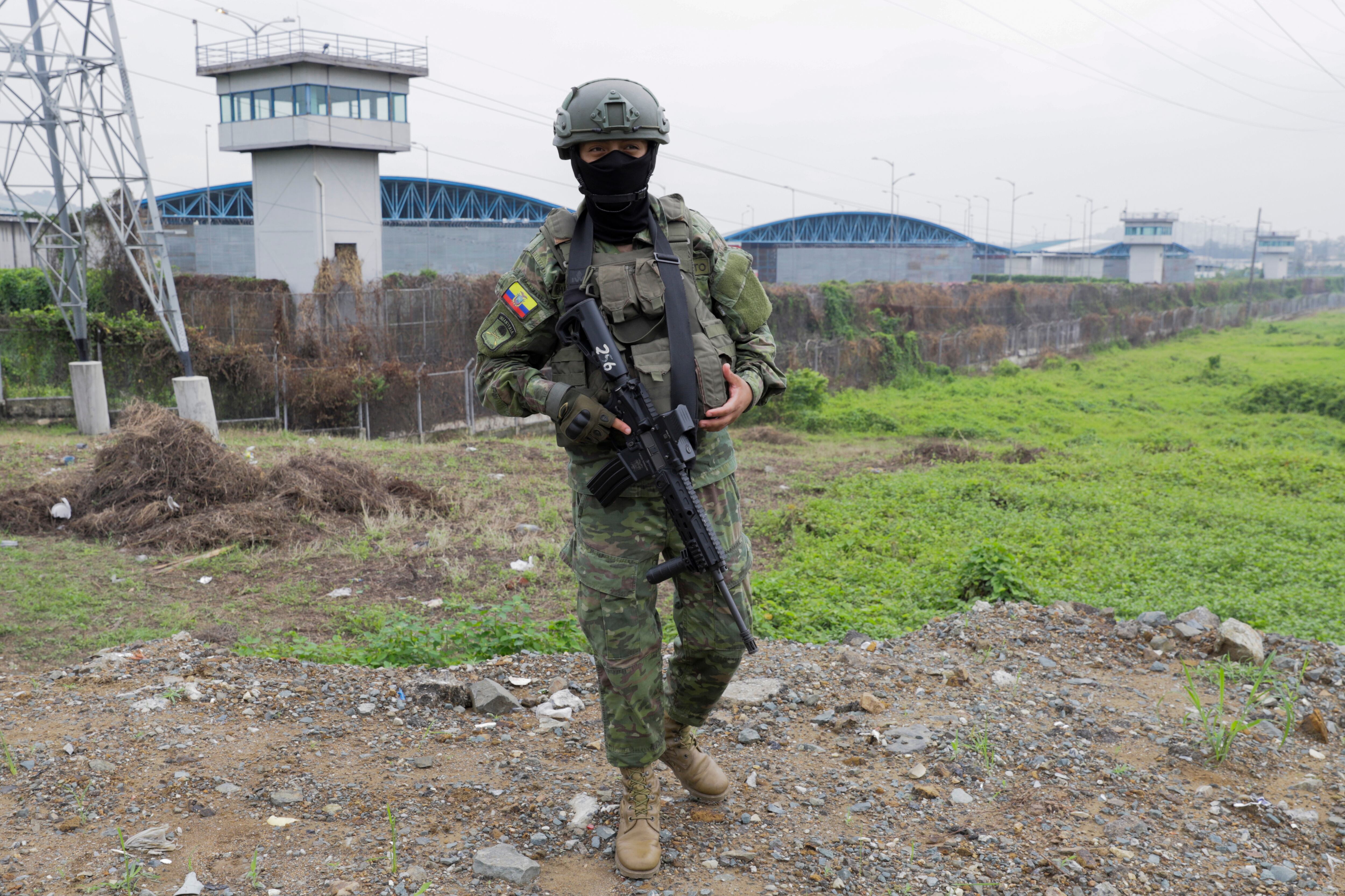 AME9794. GUAYAQUIL (ECUADOR), 14/01/2024.- Un soldado del ejército ecuatoriano vigila frente al Centro de Privación de Libertad Zonal No. 8 hoy, en Guayaquil (Ecuador). Las Fuerzas Armadas de Ecuador han detenido a 1.327 personas, 143 de ellas bajo cargos de terrorismo, en los últimos seis días de aplicación de un estado de excepción declarado por el Gobierno, con el que intenta superar la ola de violencia desatada por bandas de delincuentes en las cárceles y en las calles. EFE/ Carlos Durán Araújo