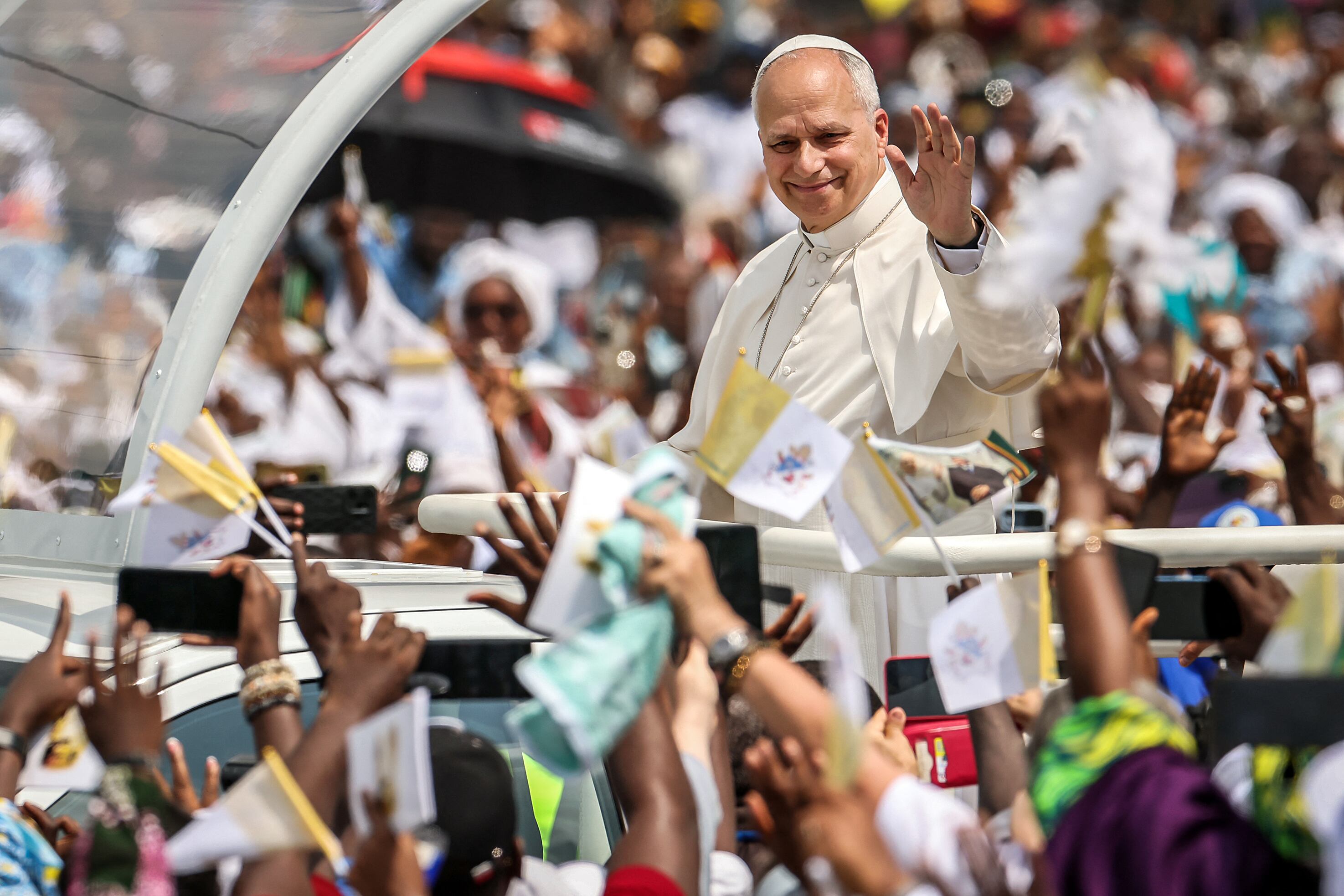 Papa Leon XIV waves to the crowd from the Popemobile as he arrives to lead the Holy Mass at the area in front of Japoma Stadium in Douala on the fifth day of an 11-day apostolic journey to Africa, on April 17, 2026. (Photo by Daniel Beloumou Olomo / AFP)
