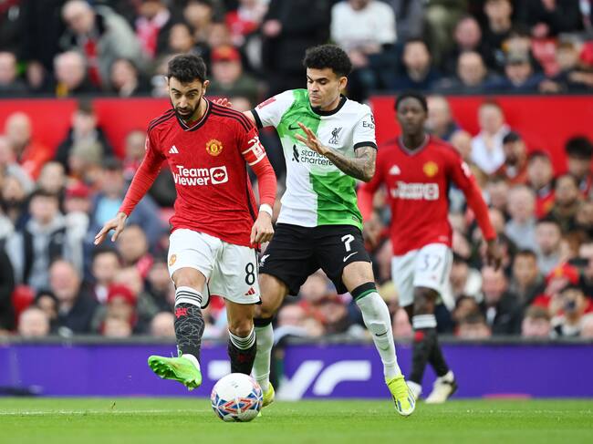 Luis Díaz disputando una pelota con Bruno Fernandes. (Photo by Michael Regan/Getty Images)