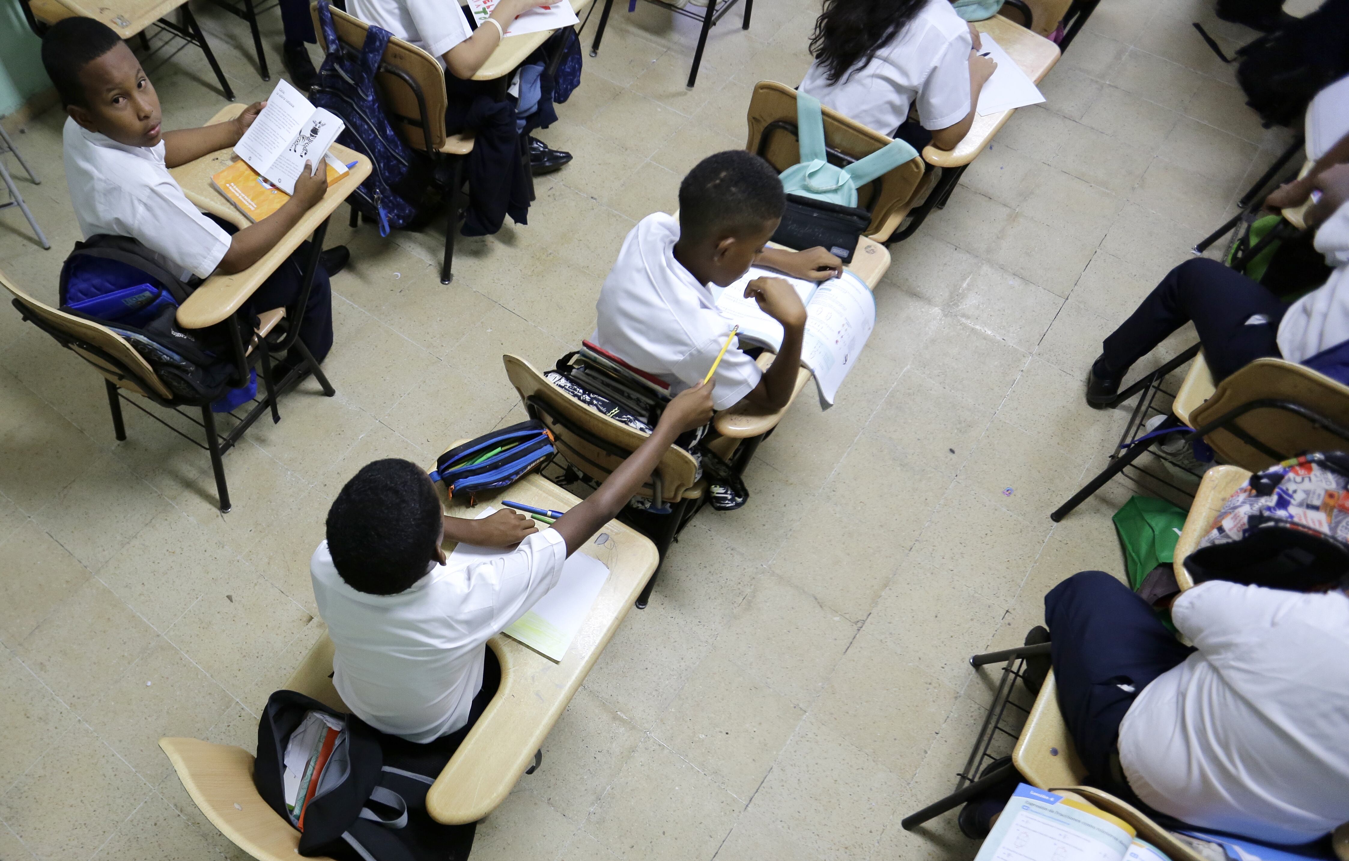 AME1975. CIUDAD DE PANAMÁ (PANAMÁ), 04/12/2023.- Fotografía que muestra estudiantes mientras asisten a clase hoy en la escuela bilingüe Severino hernandez, en Ciudad de Panamá (Panamá). Miles de estudiantes panameños de la educación pública regresaron este lunes a las aulas, después de que los gremios de docentes alcanzaran un acuerdo con el Ministerio de Educación para poner fin a más de un mes de huelga, que afectó a unos 800.000 alumnos, para presionar contra el contrato ley entre el Estado y Minera Panamá, filial de la canadiense First Quantum Minerals (FQM). EFE/Carlos Lemos