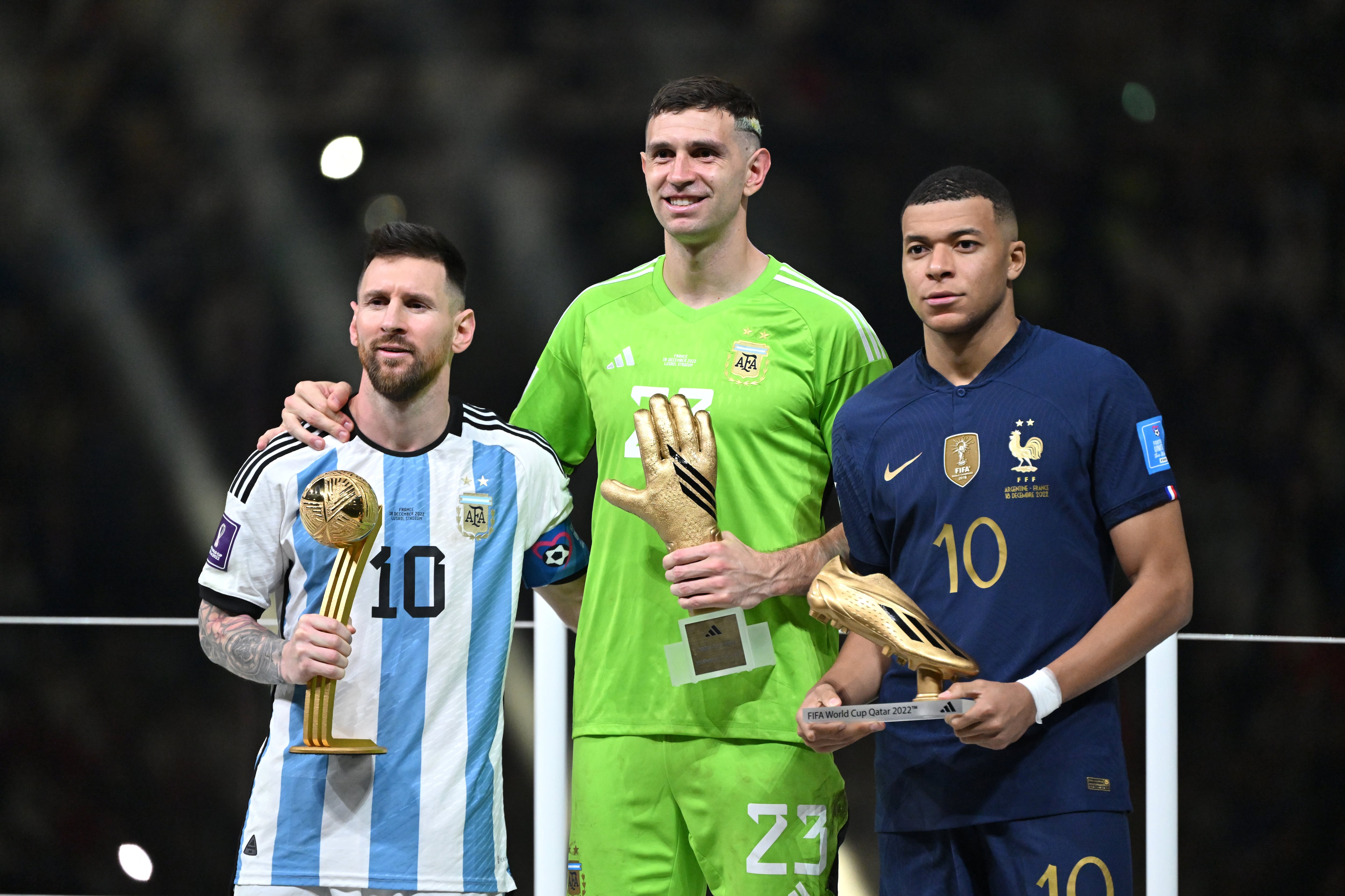 Lionel Messi, Emiliano Martinez y Kylian Mbappé en la ceremonia de premiación. (Photo by Lionel Hahn/Getty Images)