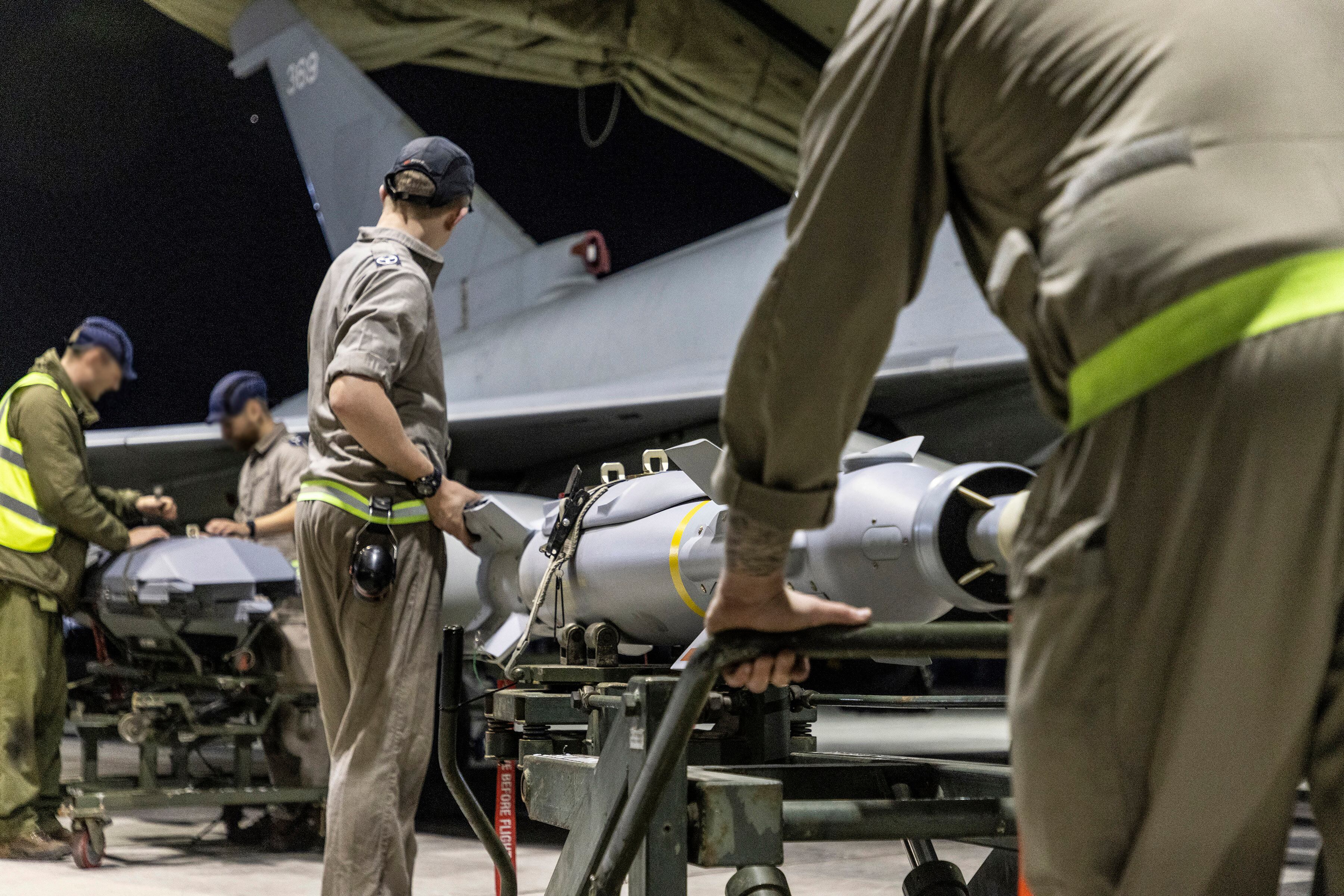 A handout picture released by the British Ministry of Defence (MOD) on February 24, 2024 shows a Royal Air Force Typhoon FGR4 having Paveway IV weapons loaded by Weapon Technicians at RAF Akrotiri in Cyprus, in preparation for a strike on military targets in Yemen. AFP.