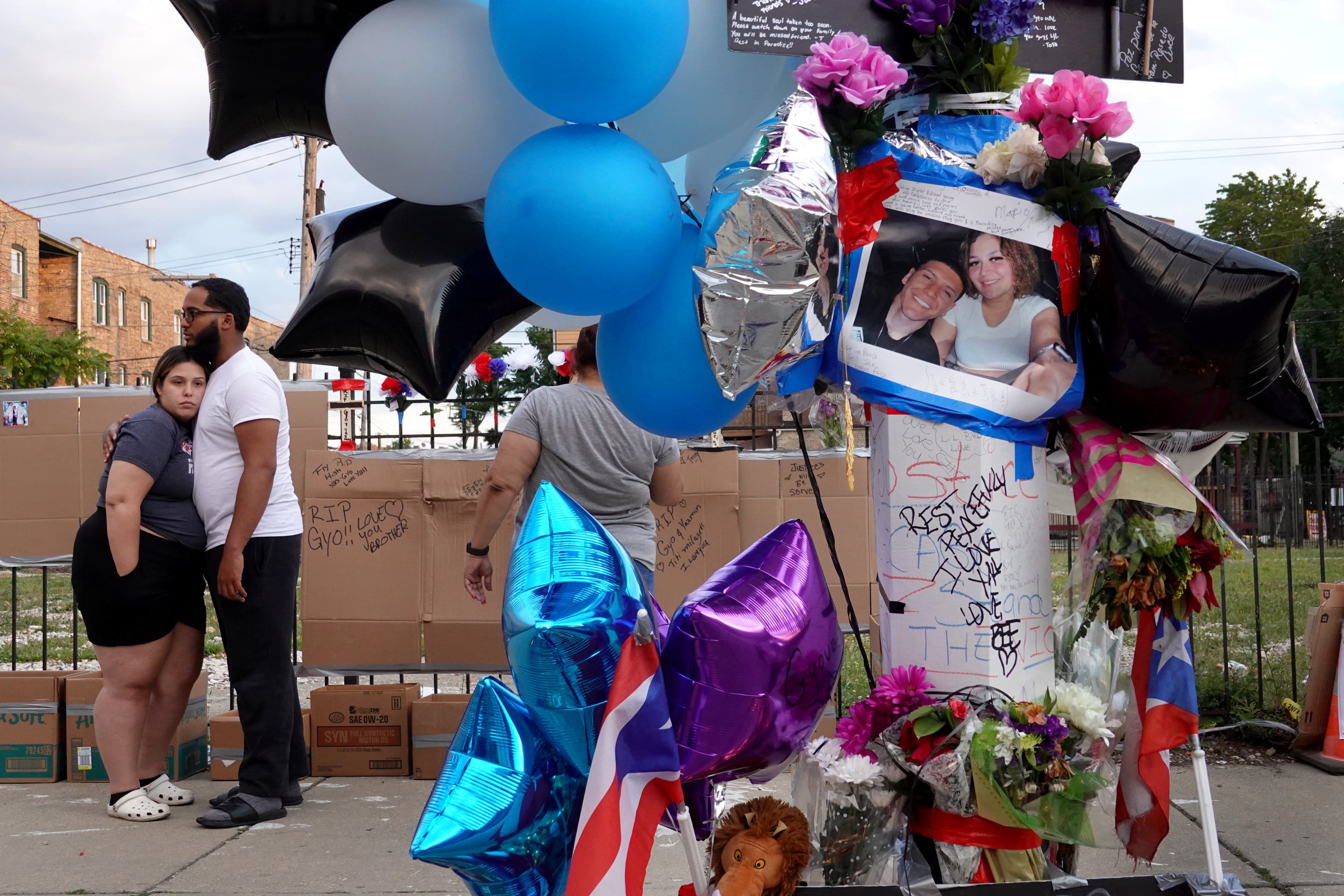 CHICAGO, ILLINOIS - JUNE 22: Mourners gather to remember Gyovanni Arzuaga, 24, and Yasmin Perez, 25, at a makeshift memorial at the location where both were shot during an altercation following a minor traffic accident as they celebrated their Puerto Rican heritage Saturday in the Humboldt Park neighborhood on June 22, 2021 in Chicago, Illinois. Arzuaga was rushed to the hospital with a gunshot would to the head where he was pronounced dead on Saturday. Perez died today from a gunshot wound to the neck. The young couple leave behind two children. (Photo by Scott Olson/Getty Images)