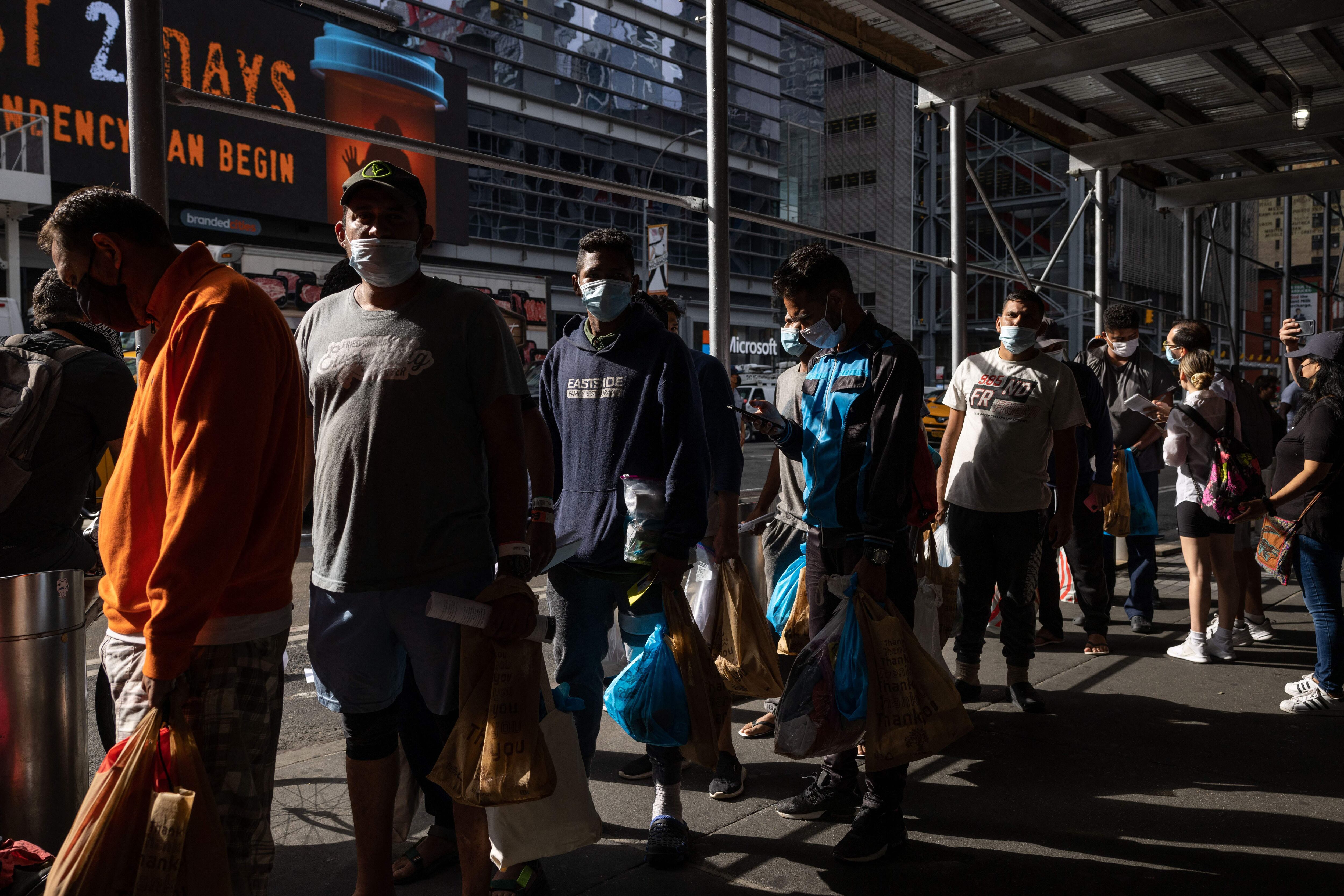 A group of migrants wait in line after arriving from Texas - Getty Images