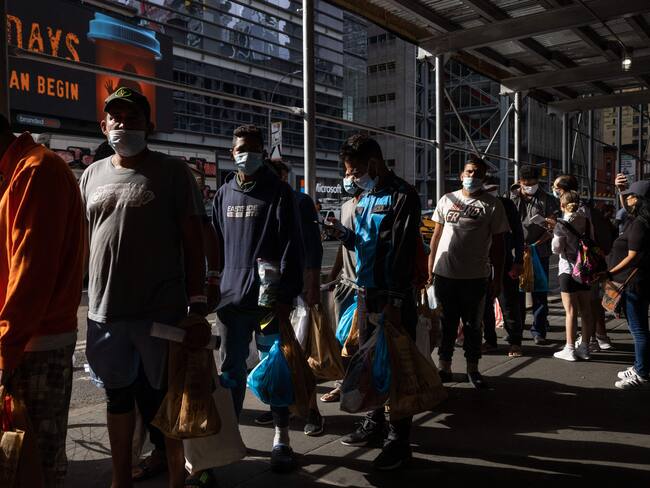 A group of migrants wait in line after arriving from Texas - Getty Images