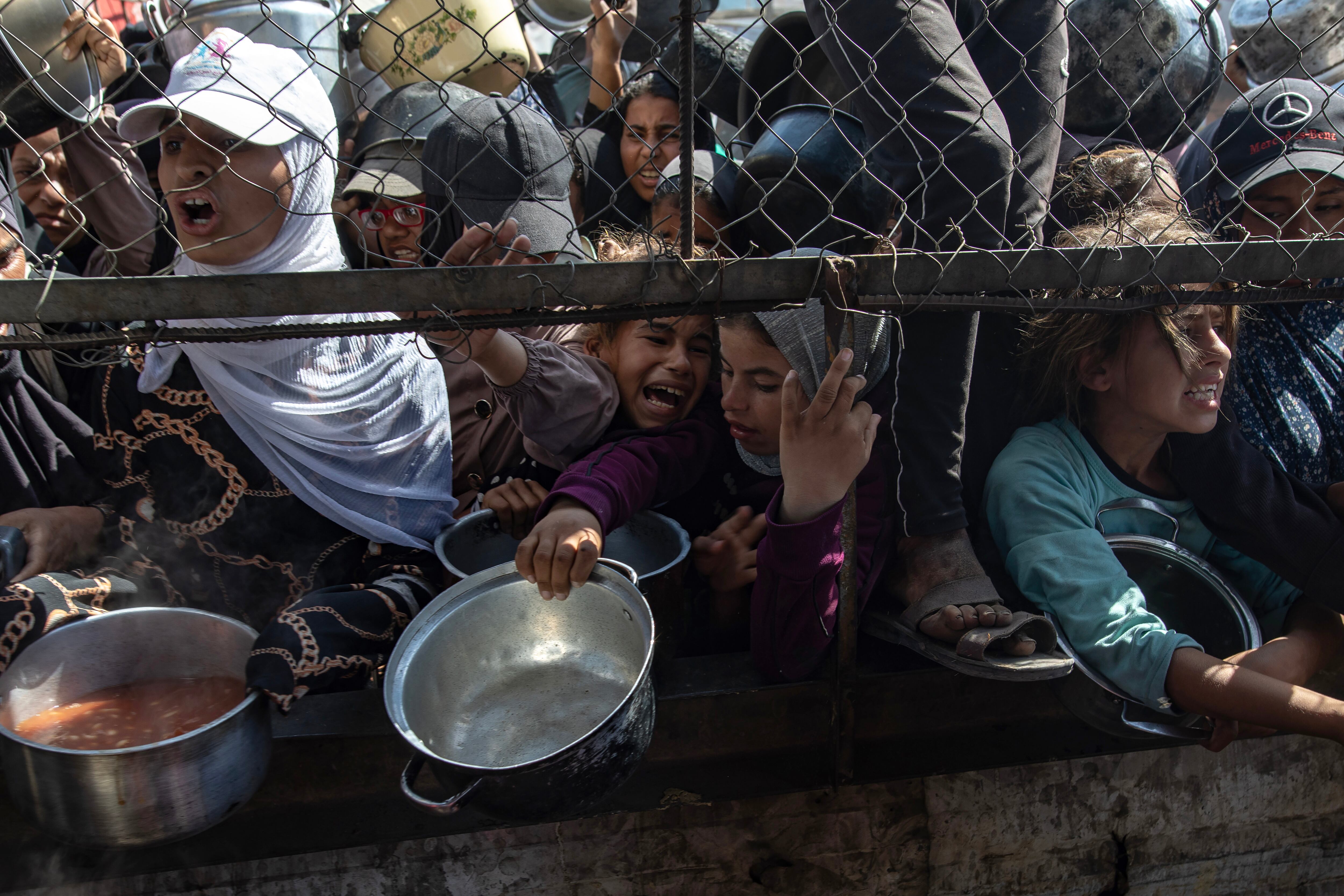 GAZA (-), 30/05/2025.- Internally displaced Palestinians gather outside a charity kitchen to receive limited rations amid a shortage of food, in Khan Younis, southern Gaza Strip, 30 May 2025. The United Nations has warned that "the entire population of Gaza is facing the risk of famine" since Israel closed border crossings on 02 March 2025, preventing the entry of essential supplies. The Gaza Government Media Office reported on 24 May that at least 58 people died due to malnutrition, and nearly 250 others due to a lack of food and medicine. EFE/EPA/HAITHAM IMAD