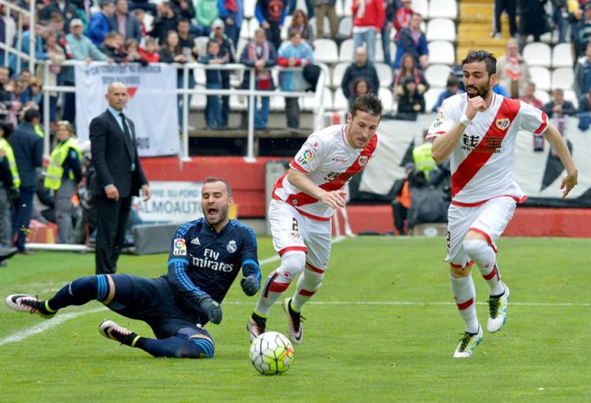 El delantero del Real Madrid Jesé Rodríguez (i) en el suelo ante los jugadores del Rayo Vallecano, Roberto Román Triguero (c) y José Ángel Crespo (d) durante el partido correspondiente a la trigésimo quinta jornada de la Liga.