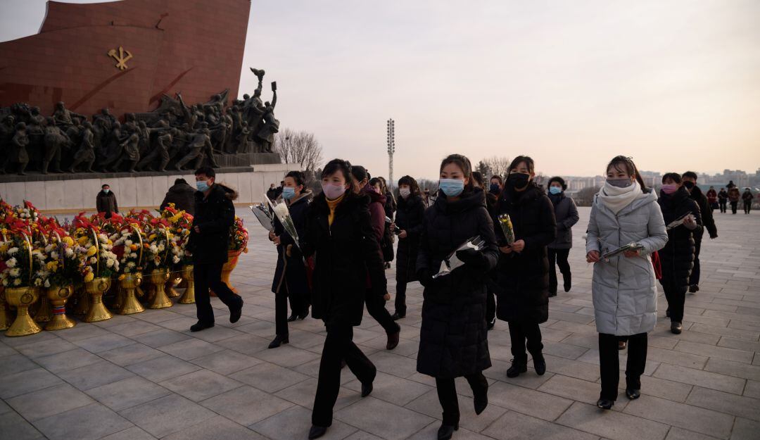 Norcoreanos visitan la estatua de Kim Jong Il durante el 79 aniversario de su nacimiento en medio de la pandemia. 