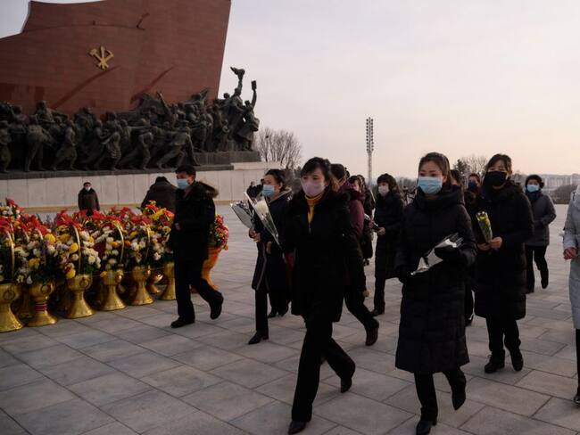 Norcoreanos visitan la estatua de Kim Jong Il durante el 79 aniversario de su nacimiento en medio de la pandemia. 