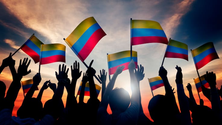 Personas alzando la bandera de Colombia (Foto vía Getty Images)