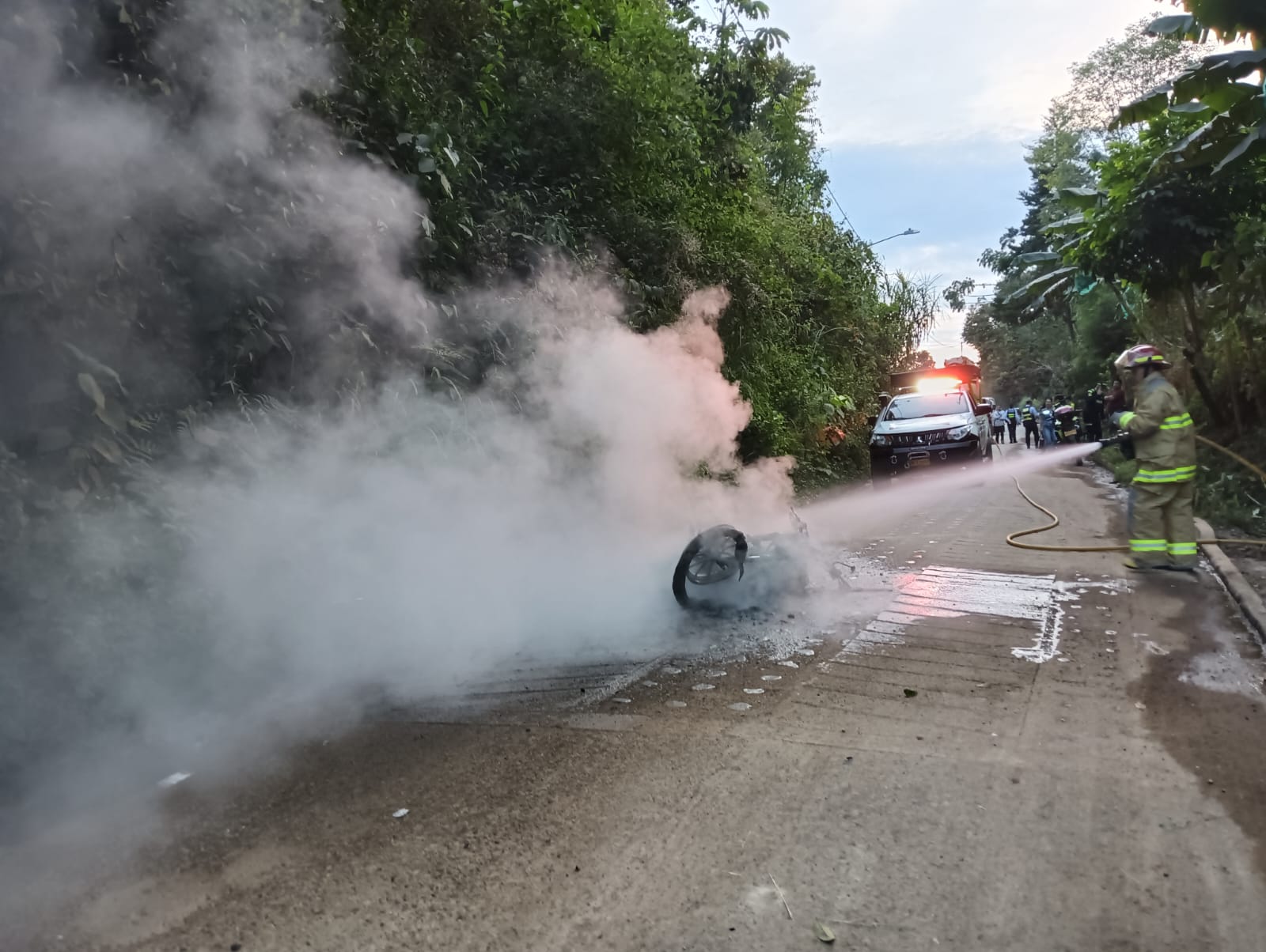 Un integrante de bomberos sofocando las llamas de la motocicleta. Foto: Cuerpo de Bomberos de Anserma.