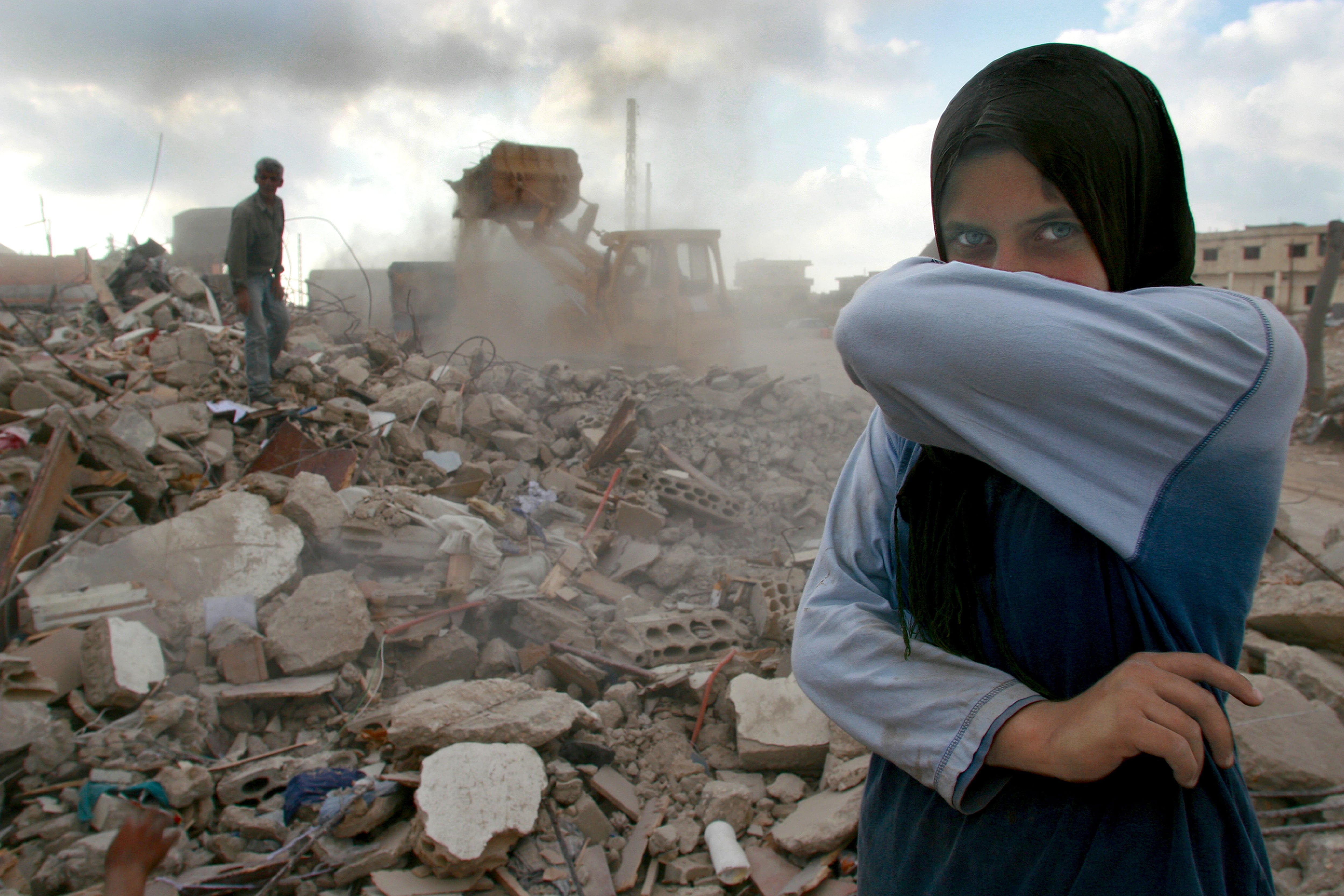 Lebanon, Sidiken, Girl in destroyed town covering mouth from ashes, portrait: Getty Images