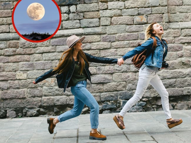 Dos mujeres corriendo por la calle junto a la imagen de la luna llena (Getty Images)