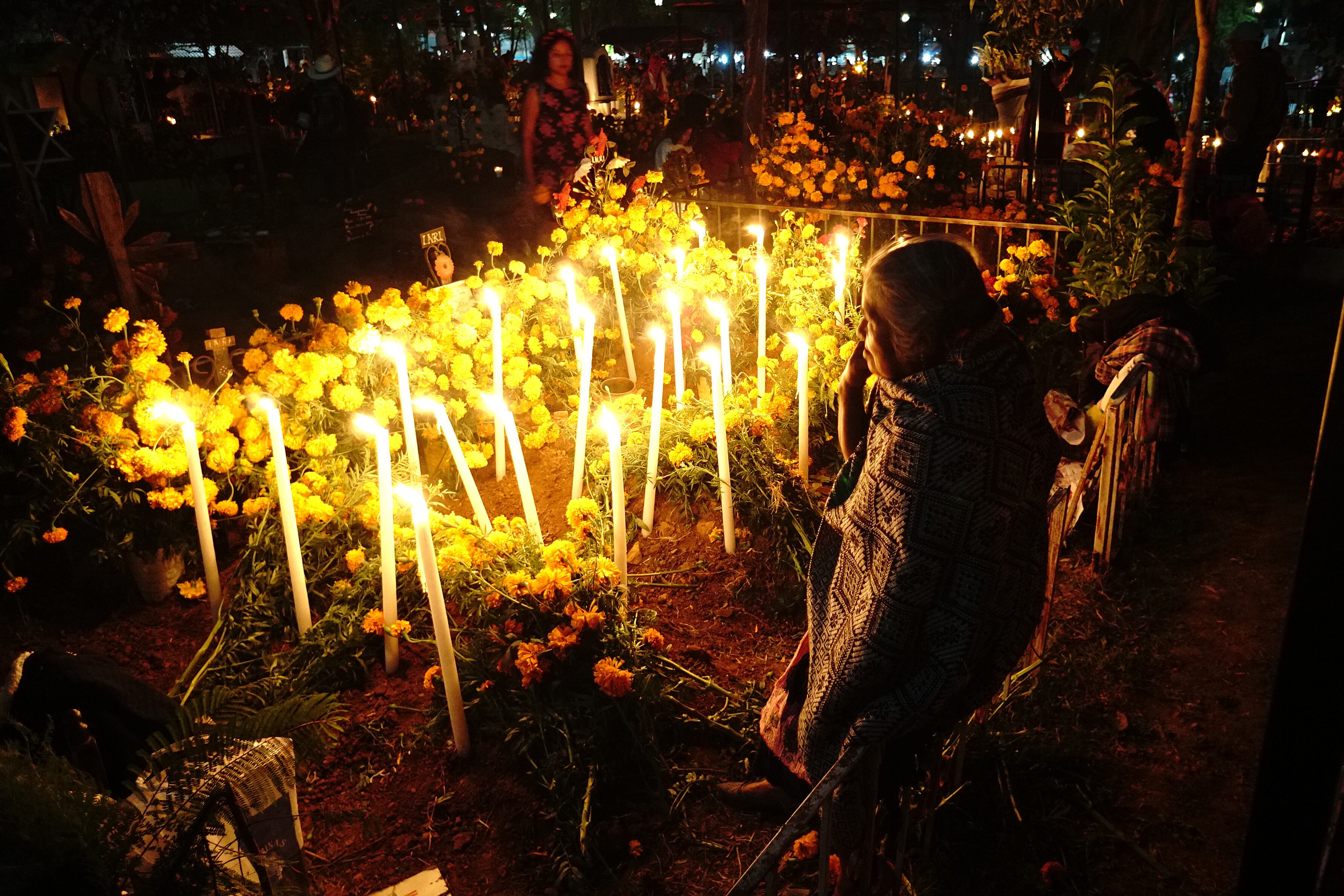 -FOTODELDÍA- MEX391. SANTA MARIA ATZOMPA (MÉXICO), 01/11/2023.- Fotografía de una tumba alumbrada con velas, en la madrugada de hoy, en Santa María Atzompa, Oaxaca (México). En el panteón de la comunidad de Santa María Atzompa celebran el Día de Muertos a través de la tradicional "Alumbrada", donde el cementerio se convierte en un faro de luz en honor a los difuntos que han partido. Los familiares mantienen viva esta tradición decorando las tumbas con ofrendas de flores de cempasúchil y velas que iluminan el camino, creando una atmósfera de reverencia y misterio en medio de la oscuridad. EFE/ Daniel Ricardez
