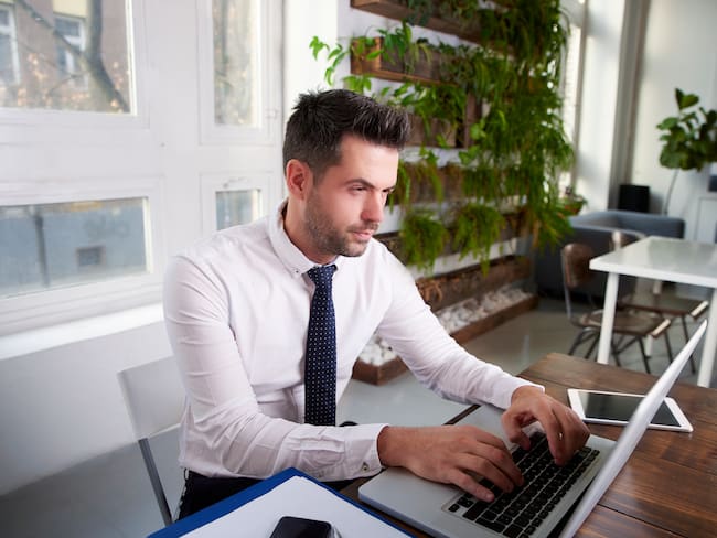 Hombre escribiendo en computador sin mirar las teclas (Getty Images).