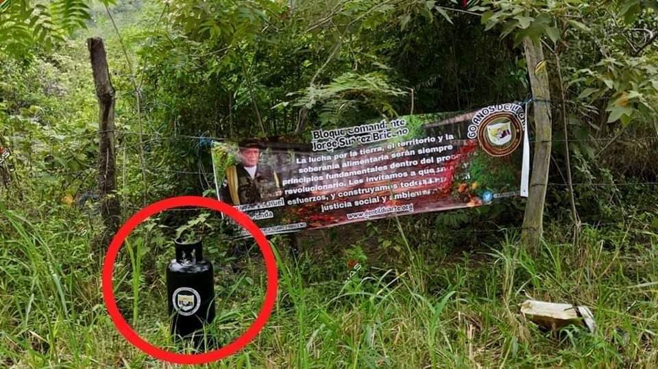 Cilindro y pancarta alusiva al grupo armado Comandante Jorge Suarez