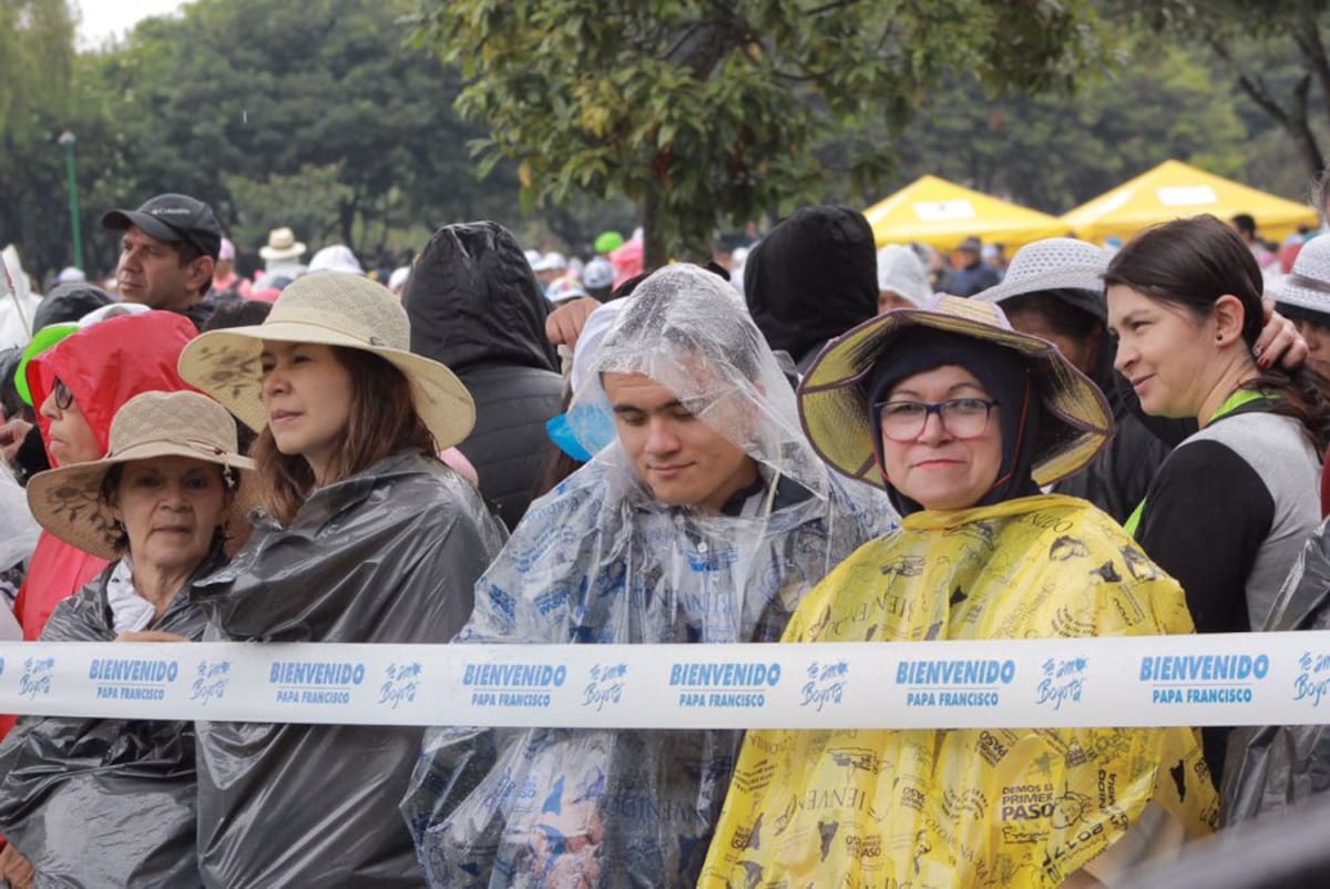 con sombreros y carpas las personas esperan al sumo pontífice