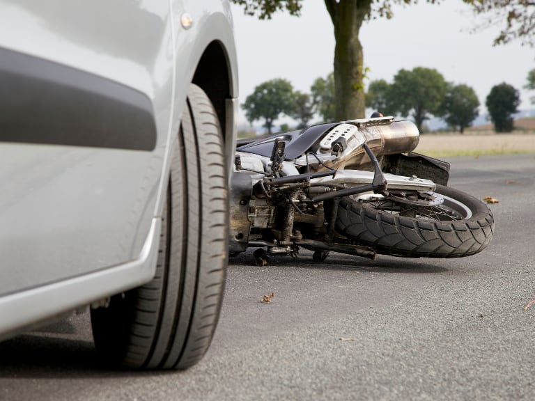 Accidente de tránsito que terminó con una moto tirada en el suelo, junto a un carro (Getty Images)