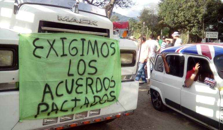 Con banderas de Colombia en sus tracto camiones los conductores protestan