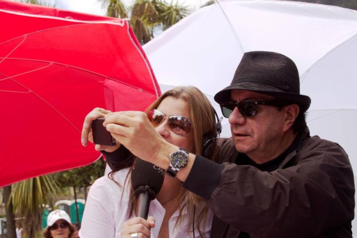 El fotógrafo Carlos Duque mostrandole a Diana Montoya cómo tomar una foto con celular.