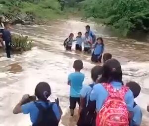 Niños wayuu cruzando el peligroso arroyo. Foto: tomada de un video.