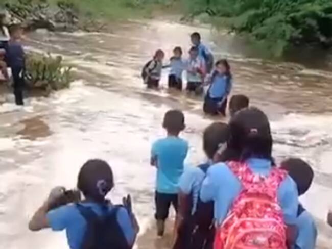Niños wayuu cruzando el peligroso arroyo. Foto: tomada de un video.